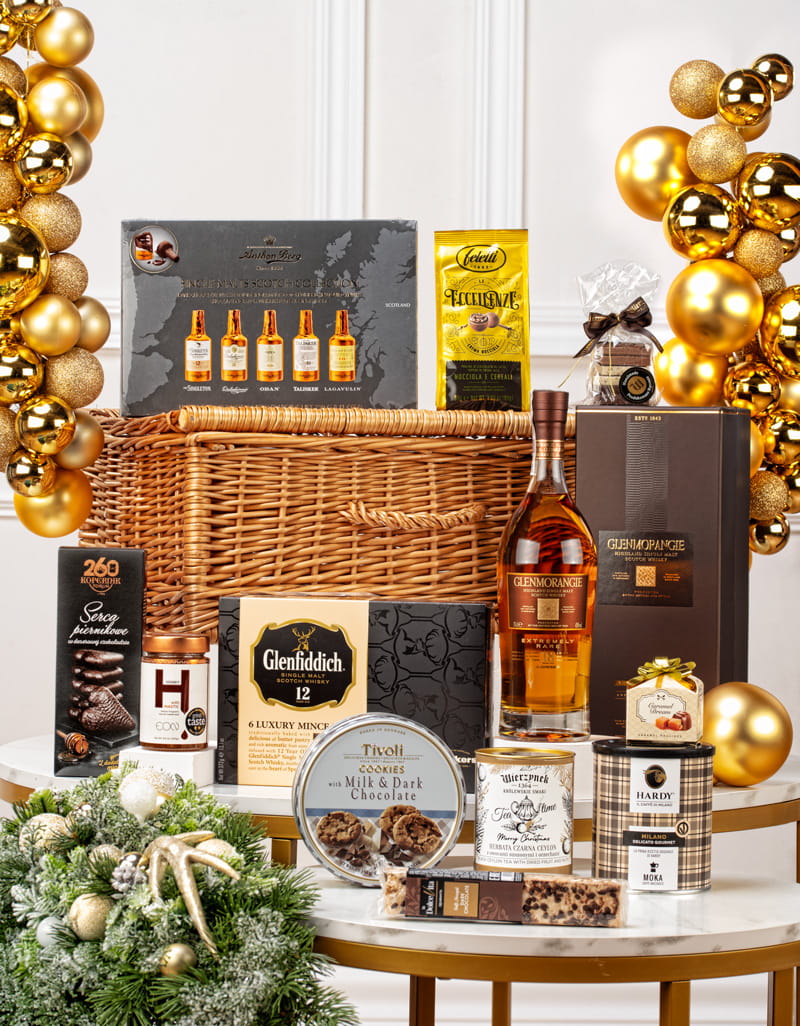 Elegancki kosz prezentowy dla konesera w wiklinowym kufrze z whisky Glenmorangie 18YO, czekoladkami Anthon Berg i kawą.