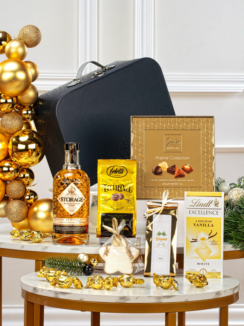 Ekskluzywny zestaw prezentowy dla pracownika w czarnym pudełku z whisky Storage, belgijskimi pralinami i herbatą.