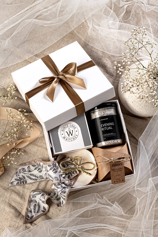 Luksusowy zestaw prezentowy dla kobiet w otwartym białym pudełku z solą Almara, świecą Mohani i spinką.