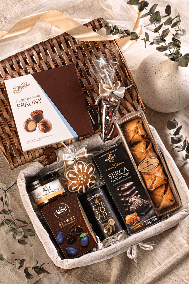 Elegancki kosz prezentowy Smaki Polski z wikliny, z miodem lipowym, pralinami Wedel, czekoladą DecoMorreno i Toruńskimi Piernikami.