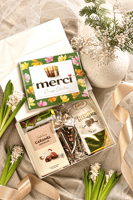 Elegancki zestaw prezentowy Słodka Podzięka w beżowym pudełku z kokardą, z czekoladkami Merci, pralinami Feletti i herbatą.