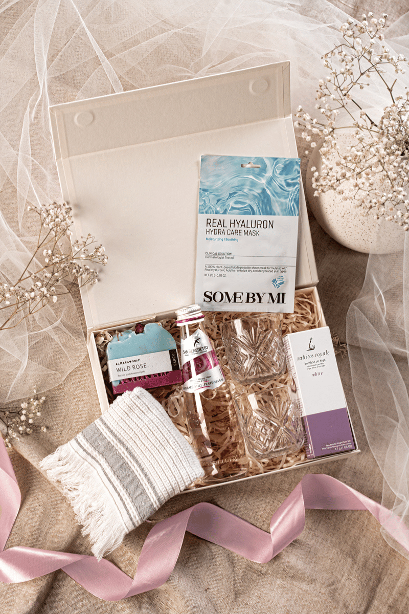 Luksusowy zestaw prezentowy dla mamy z eleganckimi szklankami Homla, mydełkiem Almara i figami Rabitos, w beżowym pudełku.