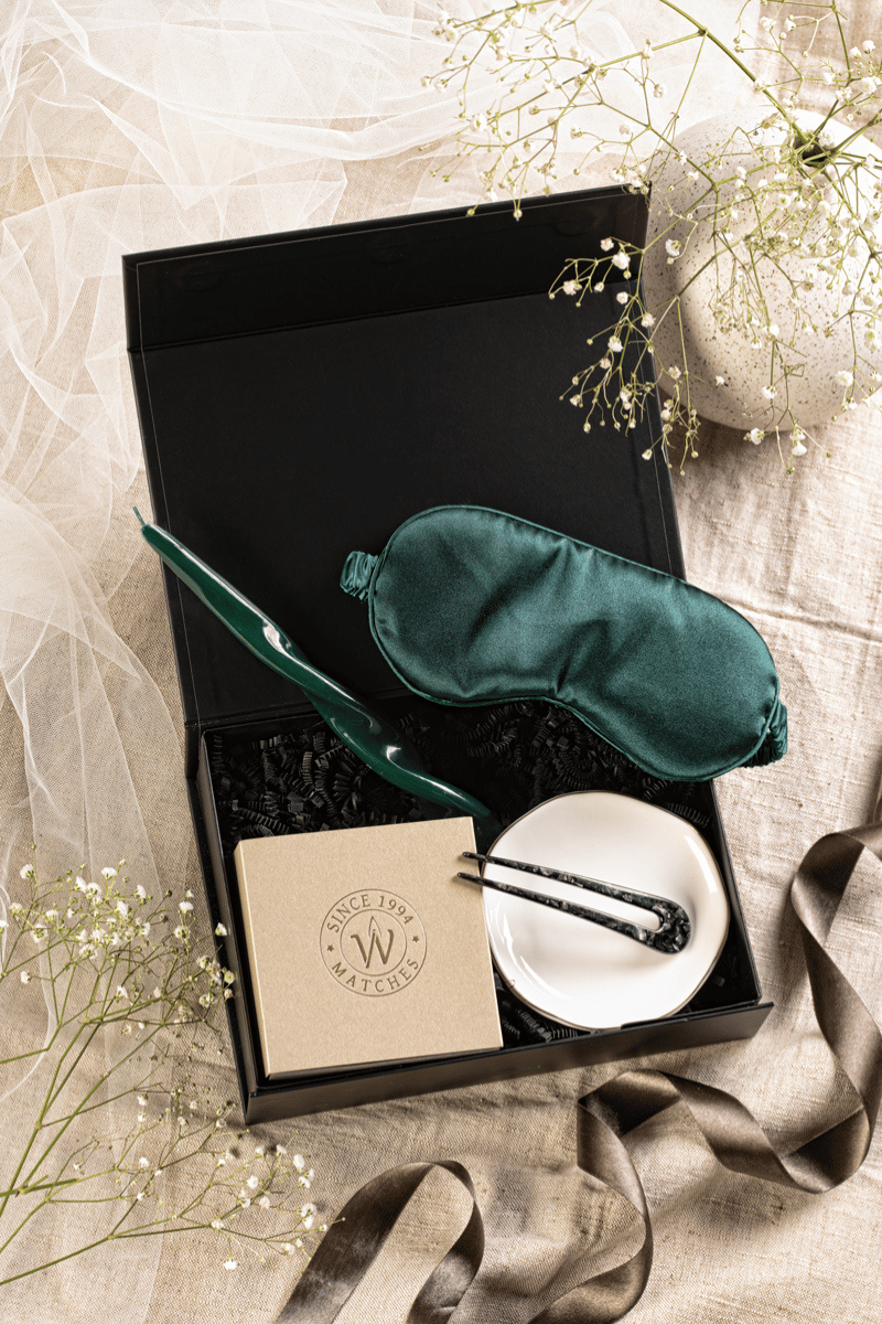 Luksusowy zestaw prezentowy do domowego SPA: zielona opaska, spiralna świeca, złota podstawka w beżowym pudełku z kokardą.