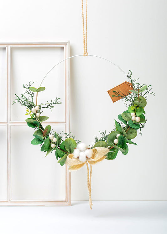 Urokliwy wianek boho z eukaliptusem i puszystym kwiatem bawełny, wiszący na drzwiach.