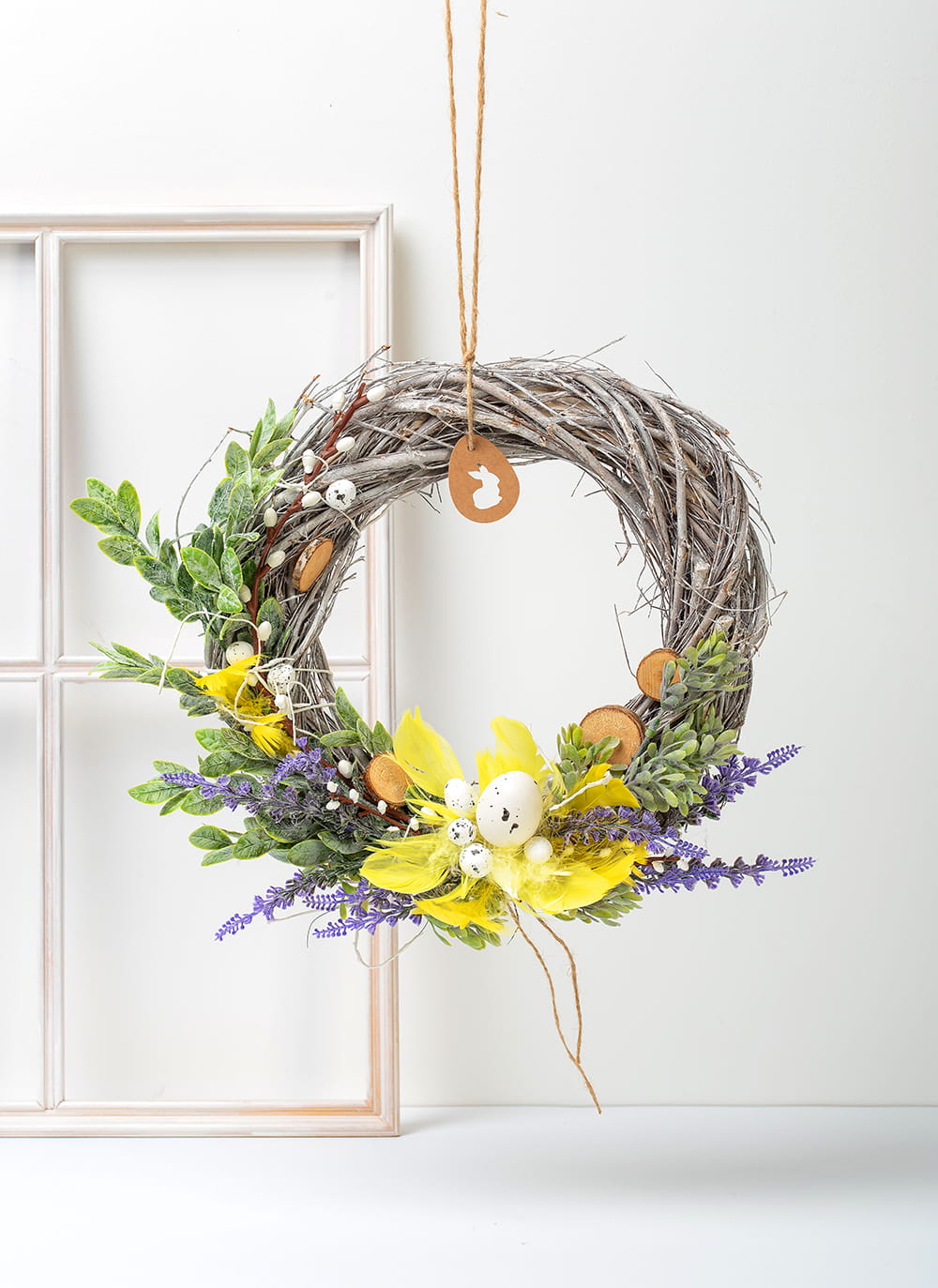 Ręcznie wykonany wiosenny wianek wielkanocny z naturalnych gałązek, bazi, lawendy, żółtych piórek i malutkich jajeczek.