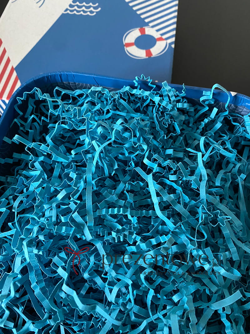 Jasnoniebieskie, puszyste wiórki papierowe ułożone w stertę, idealne jako ekologiczny wypełniacz do prezentów i paczek.