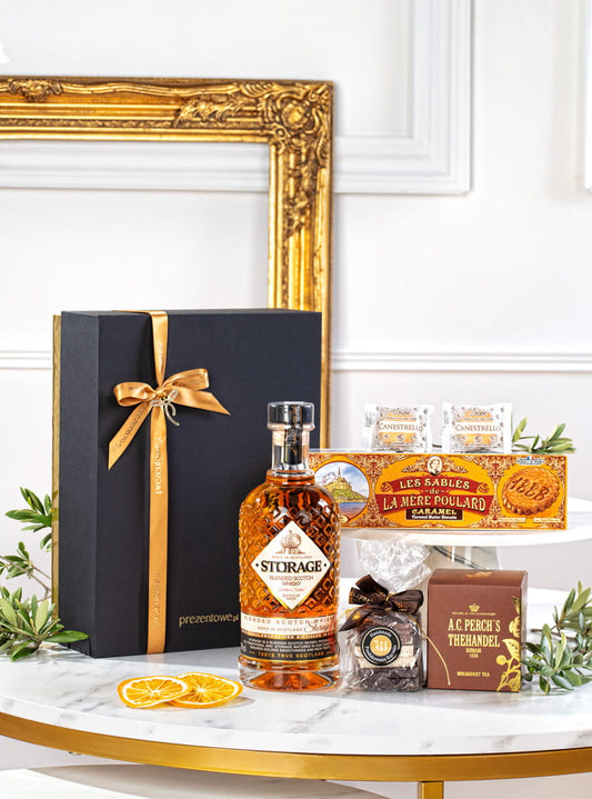 Elegancki złoty zestaw prezentowy z whisky Storage, herbatą Perch's, czekoladkami Wierzynek w luksusowym opakowaniu.