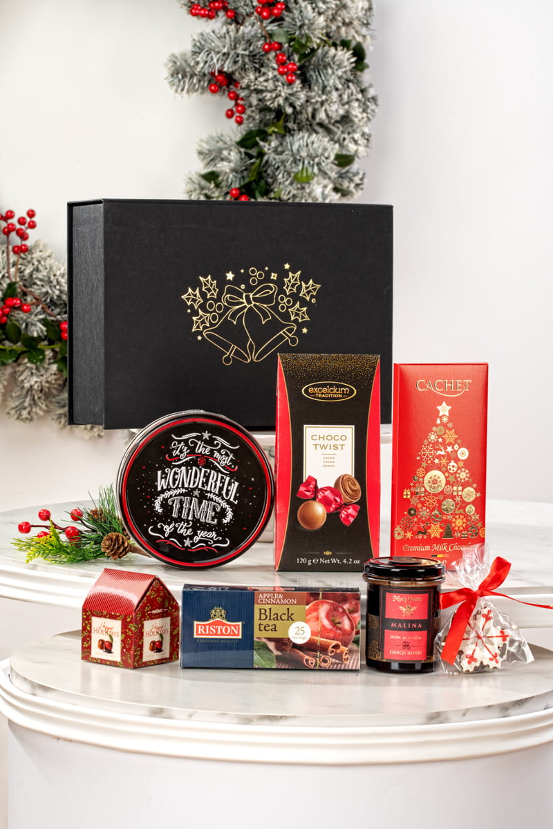 Świąteczny kosz prezentowy w czarnym pudełku ze świąteczną grafiką, z belgijskimi pralinami i herbatą Riston.