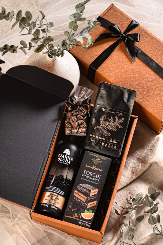 Elegancki zestaw prezentowy Polskie Smaki: wódka Czarna Olcha, kawa Gourmet, torcik Kopernik i karmelki, w brązowym pudełku z kokardą.
