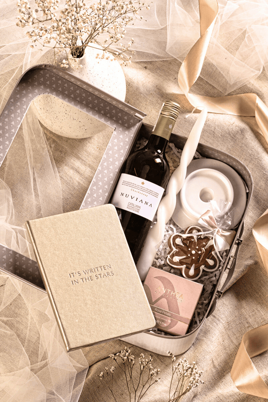 Elegancki zestaw prezentowy z winem Nuviana Chardonnay, herbatą i złotym notesem, w kremowym pudełku-walizce z okienkiem.