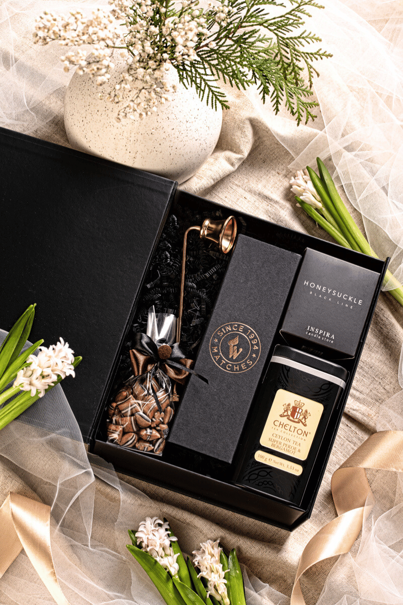 Elegancki zestaw prezentowy Chwila Spokoju w czarnym pudełku z kokardą, z herbatą liściastą Ceylon i świecą zapachową.
