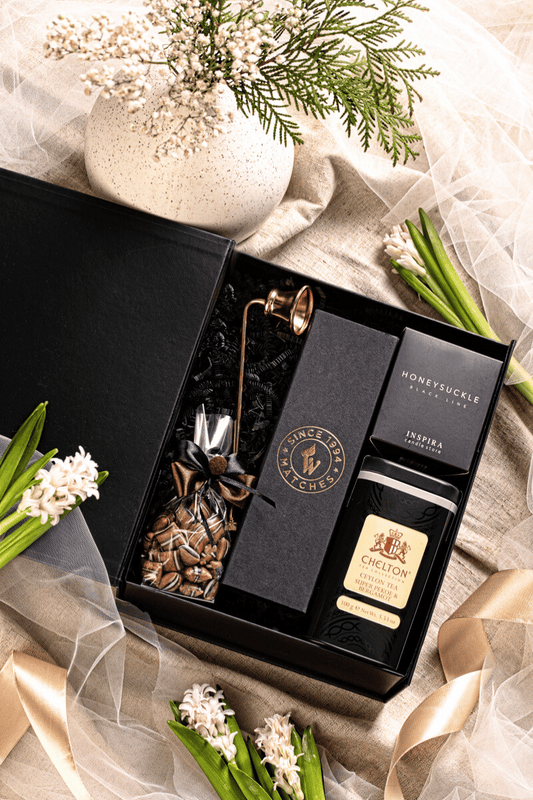 Elegancki zestaw prezentowy Chwila Spokoju w czarnym pudełku z kokardą, z herbatą liściastą Ceylon i świecą zapachową.