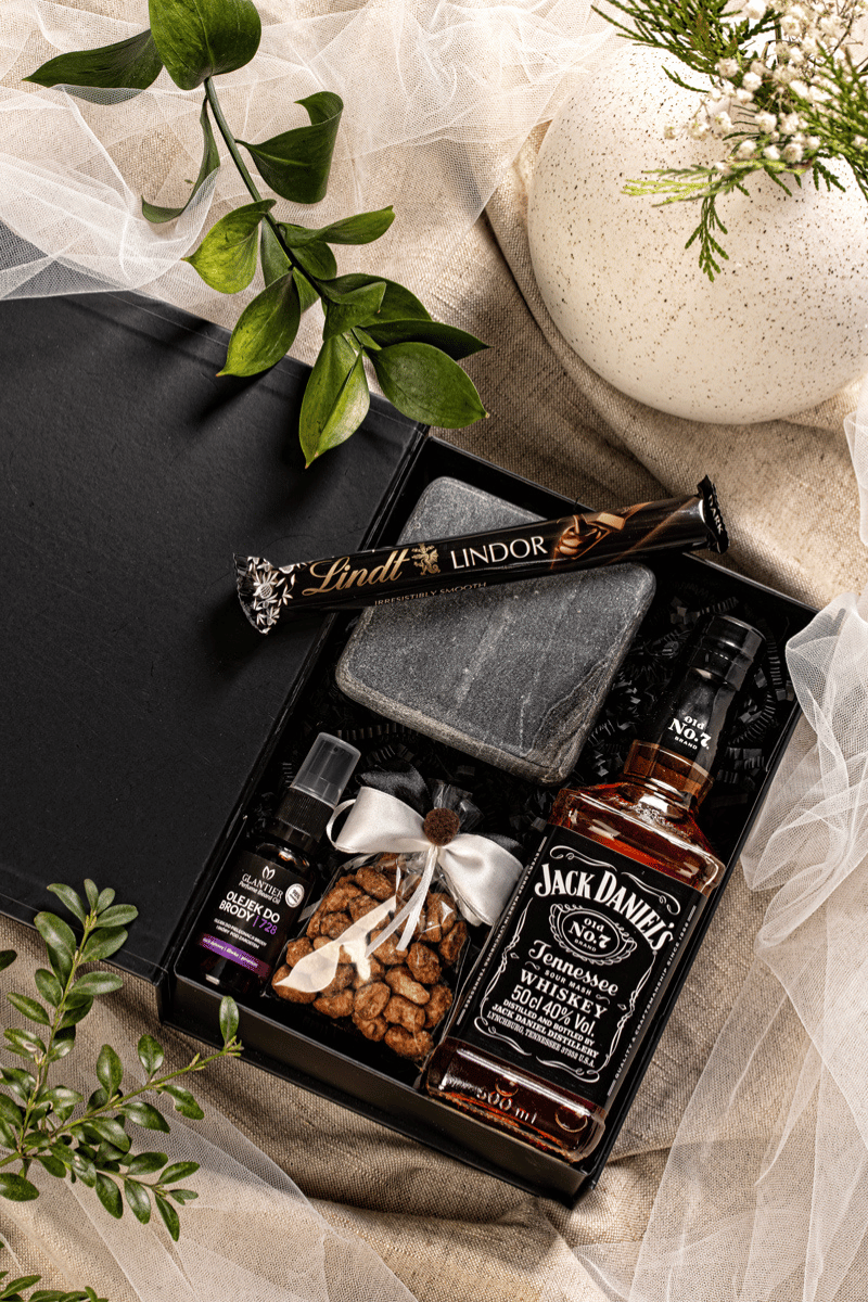 Elegancki zestaw prezentowy dla mężczyzny z whiskey Jack Daniel's, olejkiem do brody i czekoladą Lindt, w czarnym pudełku z satynową kokardą.