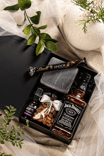 Elegancki zestaw prezentowy dla mężczyzny z whiskey Jack Daniel's, olejkiem do brody i czekoladą Lindt, w czarnym pudełku z satynową kokardą.