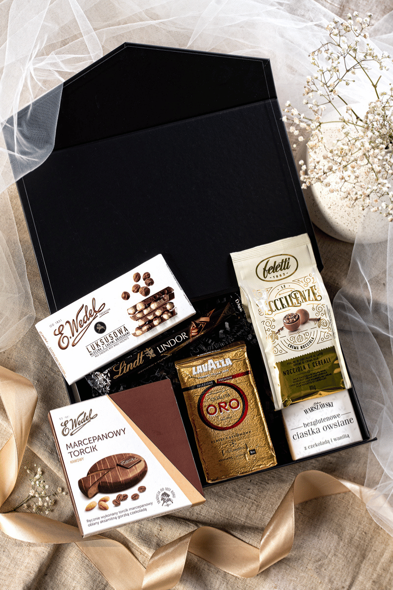 Elegancki zestaw prezentowy z kawą Lavazza, czekoladą Wedel i pralinami Feletti w czarnym pudełku z satynową kokardą.