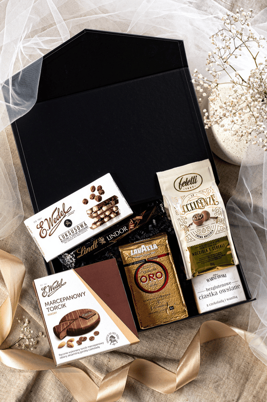 Elegancki zestaw prezentowy z kawą Lavazza, czekoladą Wedel i pralinami Feletti w czarnym pudełku z satynową kokardą.