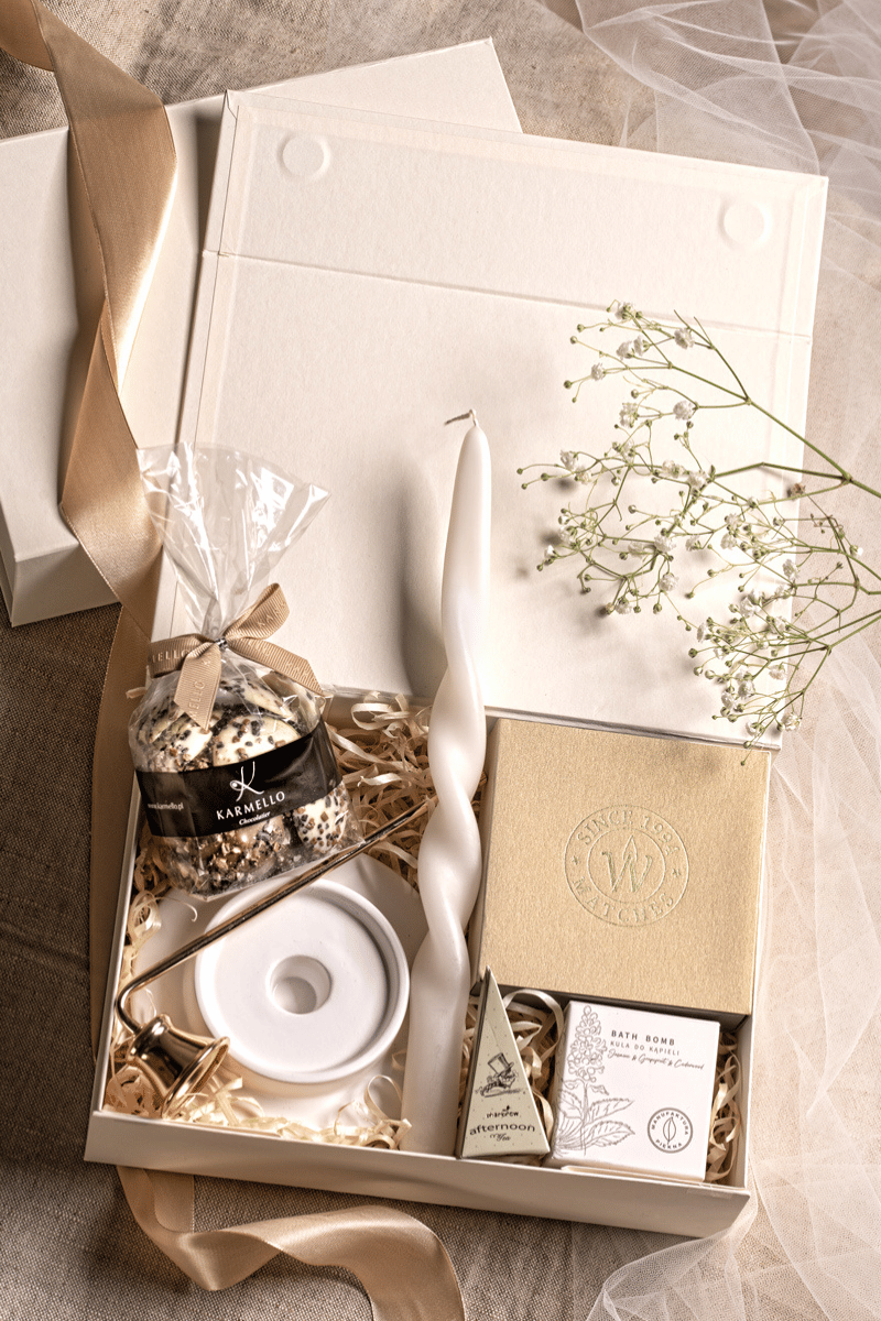 Luksusowy zestaw prezentowy Relaks: beżowe pudełko z kokardą, świeca sojowa, herbata Charbrew, czekoladki Karmello.
