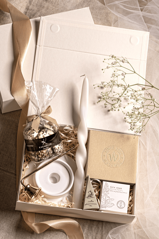 Luksusowy zestaw prezentowy Relaks: beżowe pudełko z kokardą, świeca sojowa, herbata Charbrew, czekoladki Karmello.