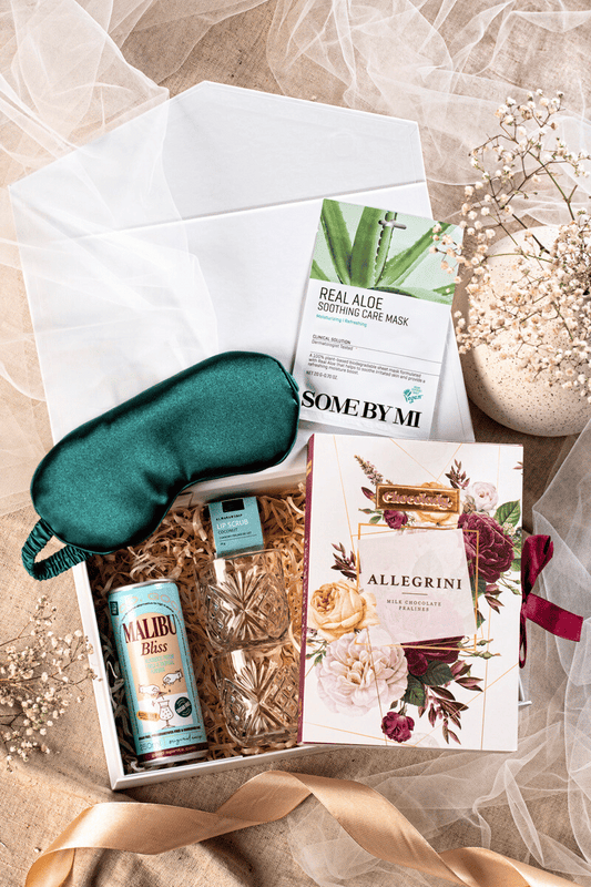 Luksusowy zestaw prezentowy w otwartym czarnym pudełku ze złotymi detalami, zawierający kawę Davidoff, praliny Lindt i wykwintne słodycze.