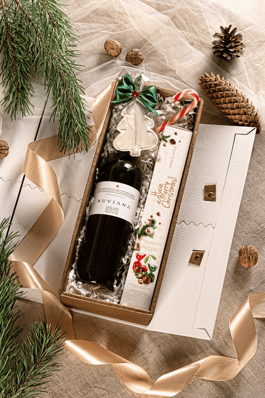 Elegancki świąteczny zestaw prezentowy z białym winem Chardonnay, pralinami i piernikiem choinkowym w pudełku z gwiazdkowym nadrukiem.
